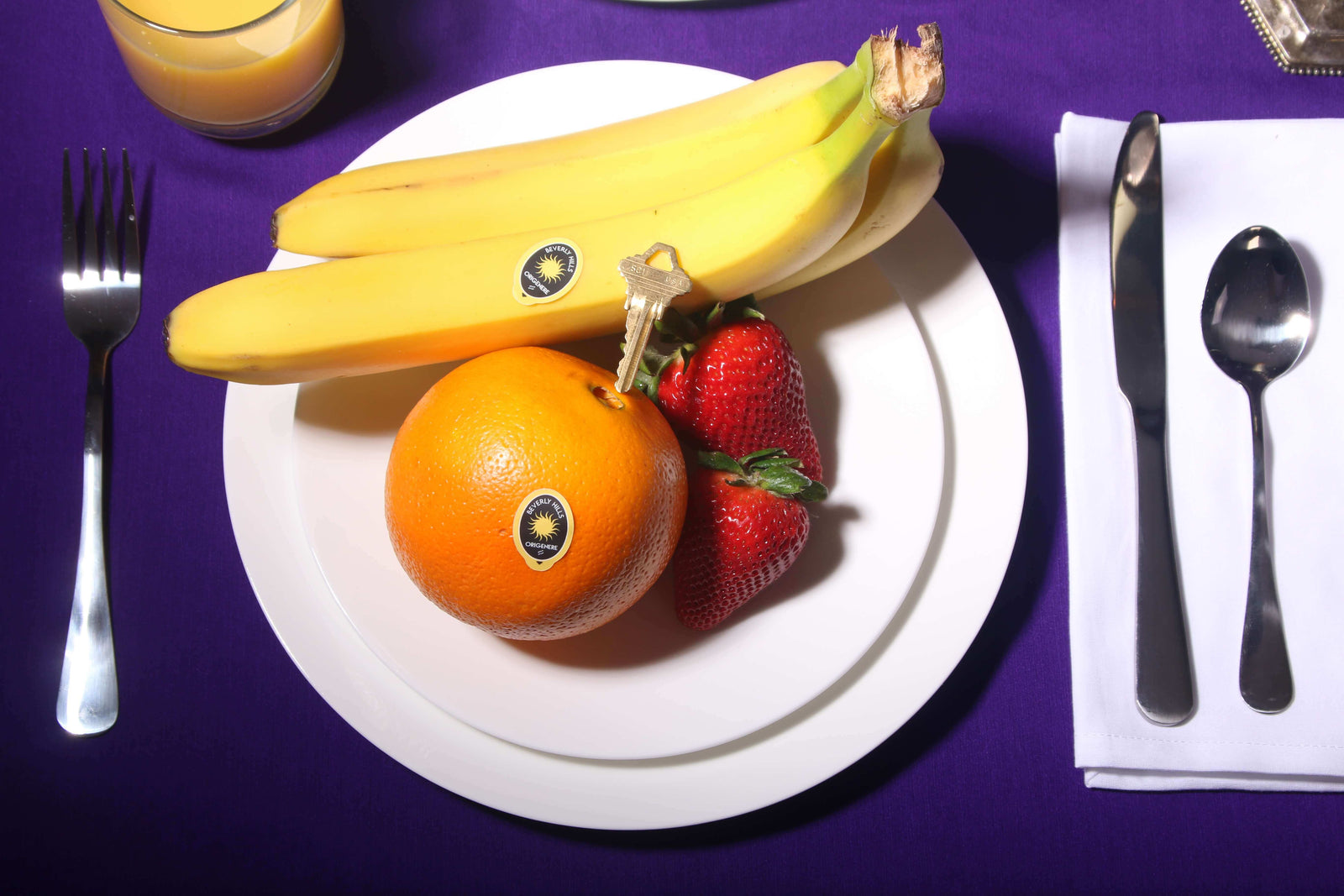 Bananas, Strawberries and an Orange with Origenere stickers on a plate with a key in the middle