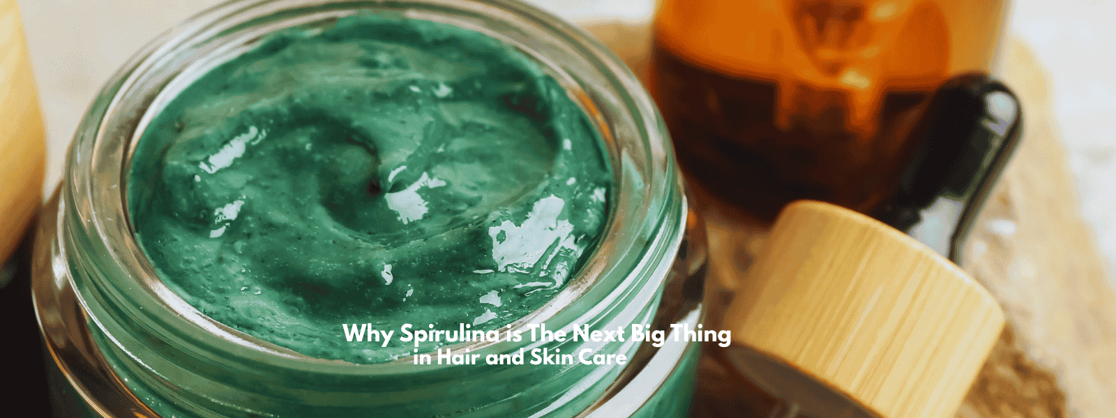 Green spirulina mask in a glass jar beside botanical oils, illustrating natural antioxidant hair and scalp care solutions