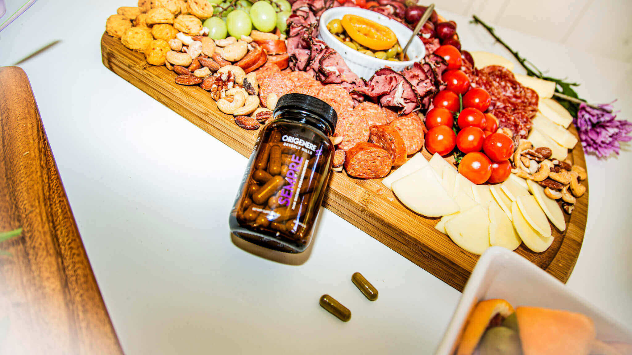 Origenere Sempre Hair Growth Vitamins displayed on charcuterie board