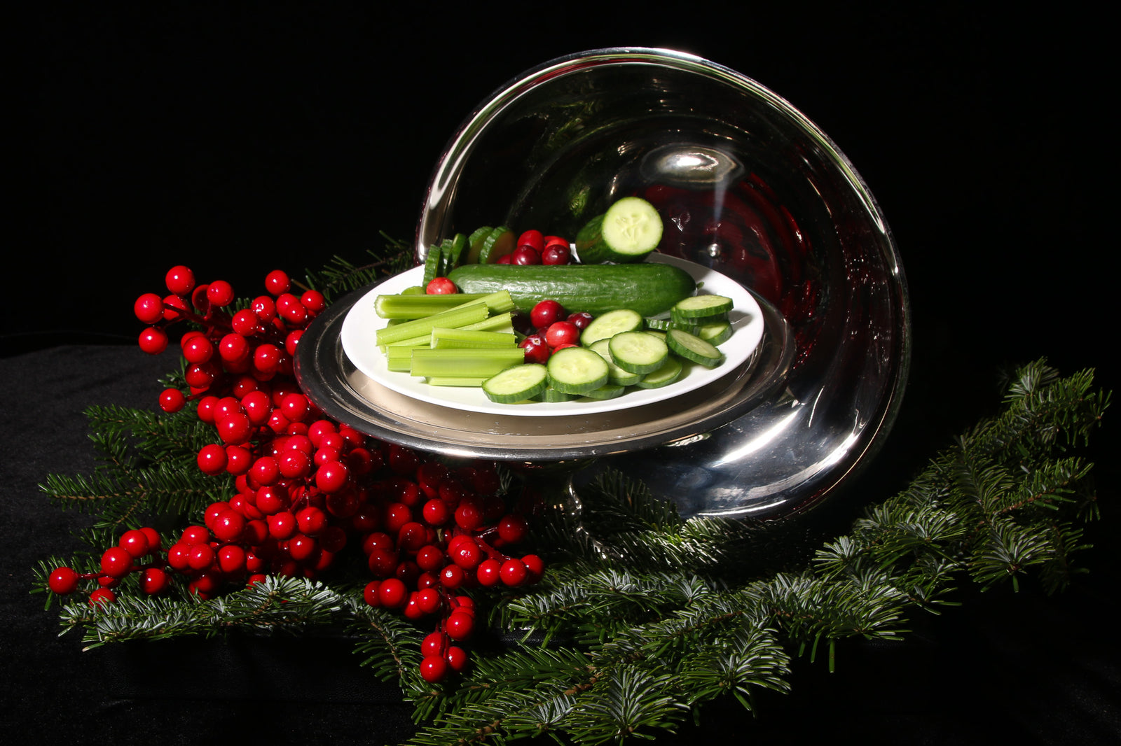 artfully displayed tray of water-rich fruits and vegetables including cucumer, pomegranates and celery