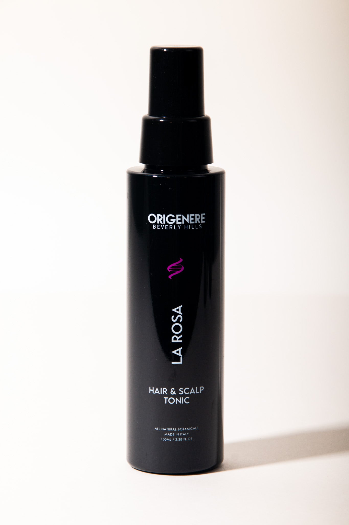 Black bottle of Origenere La Rosa Hair & Scalp Tonic on a white background